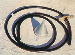 A flexible stomach tube marked with tape, a homemade gag, and funnel.